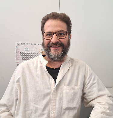 Hombre sonriente canoso con gafas y camisa blanca