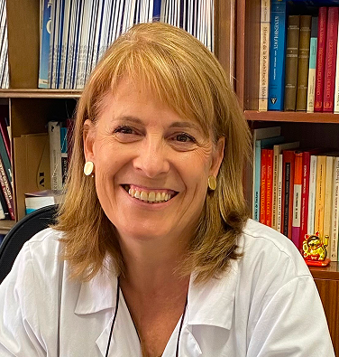 Hombre sonriente canoso con gafas y camisa blanca