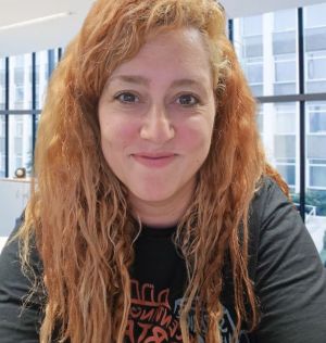 Mujer peli roja sonriente con una camiseta negra