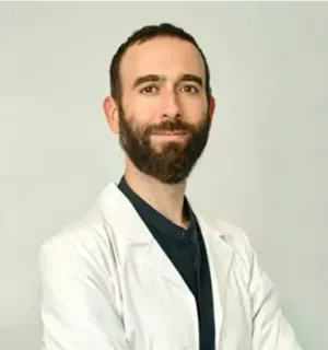 Hombre sonriente con pelo castaño y barba poblada