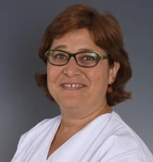 Mujer sonriente con una bata blanca, pelo por la nuca y gafas de ver