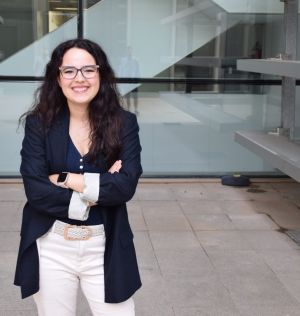 Mujer sonriente de pelo moreno con gafas y chaqueta azul marino