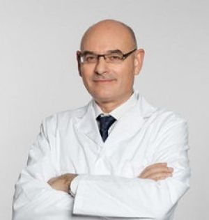 Hombre con gafas, calvo y con bata blanca cruzado de brazos